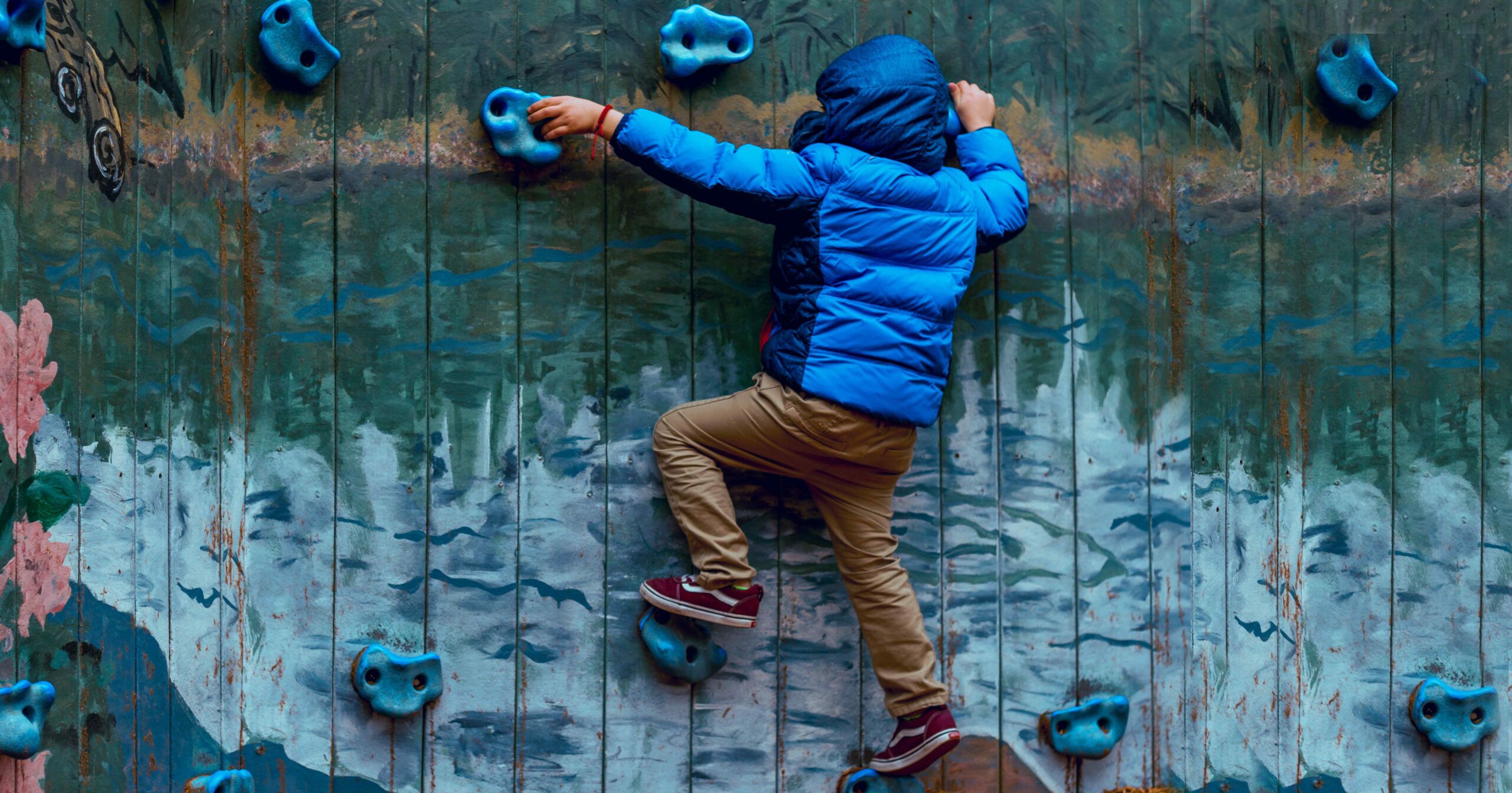 child on a rock-climbing wall