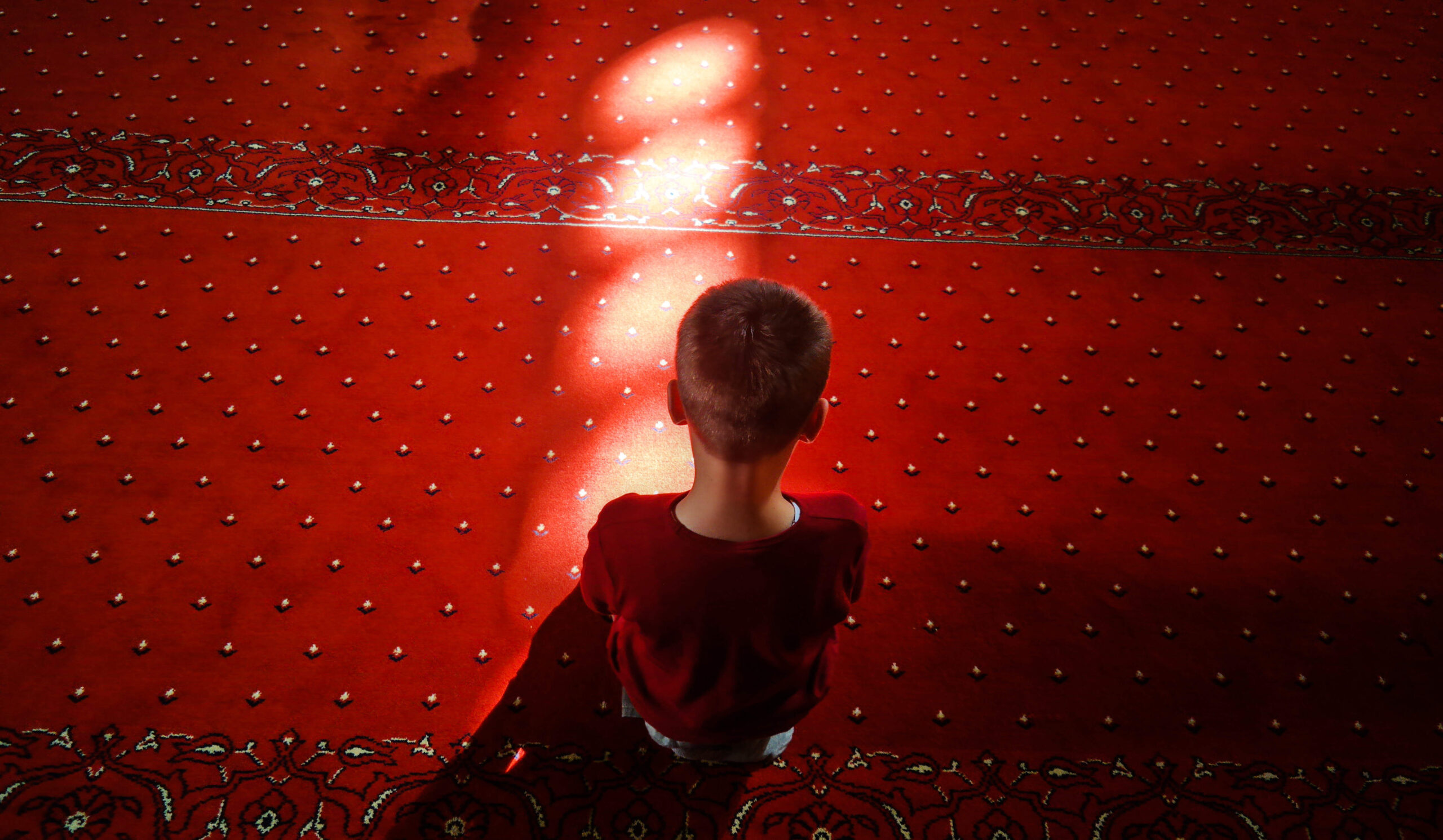 a child sitting on a red floor