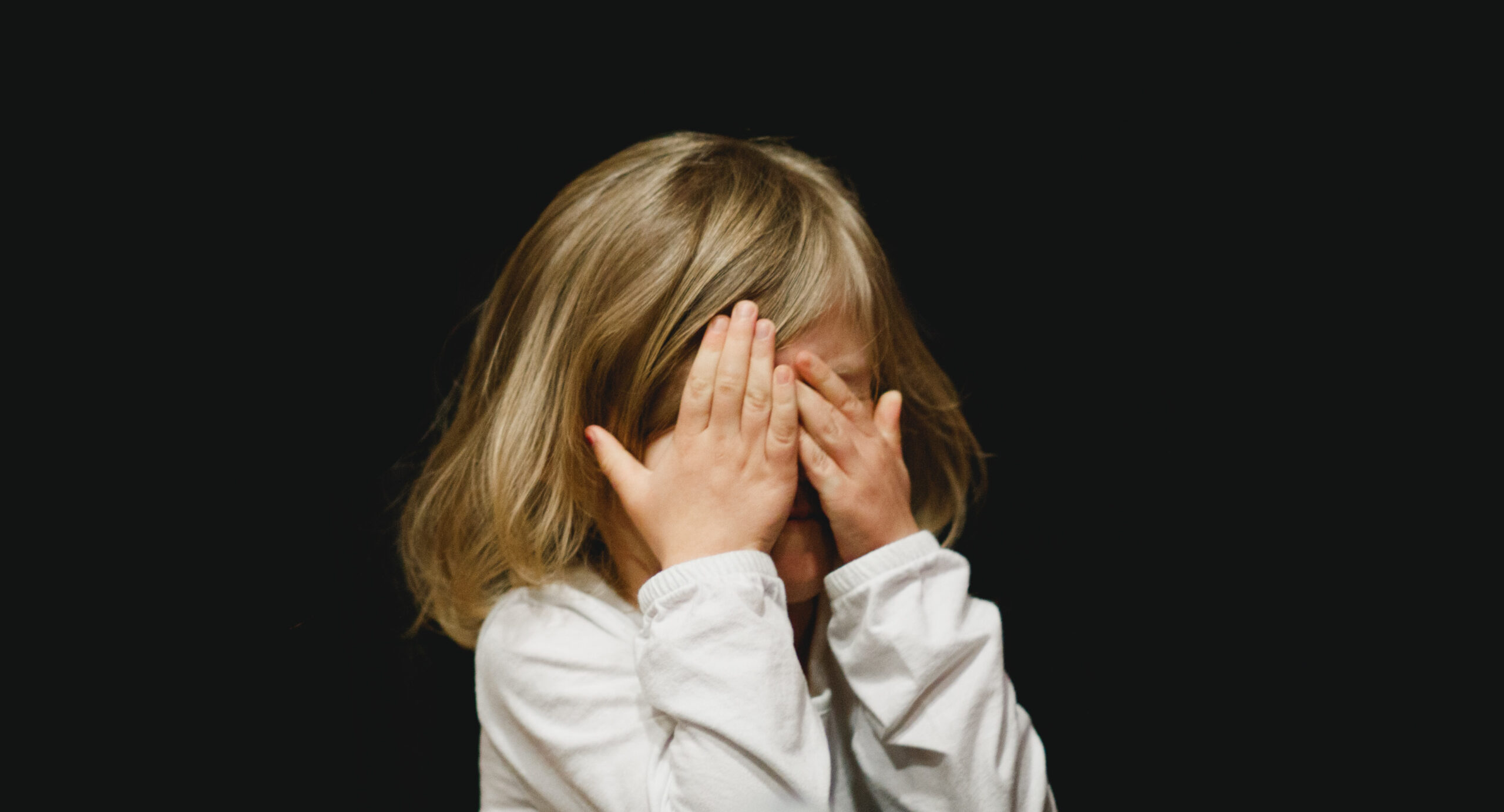 a child covering her eyes