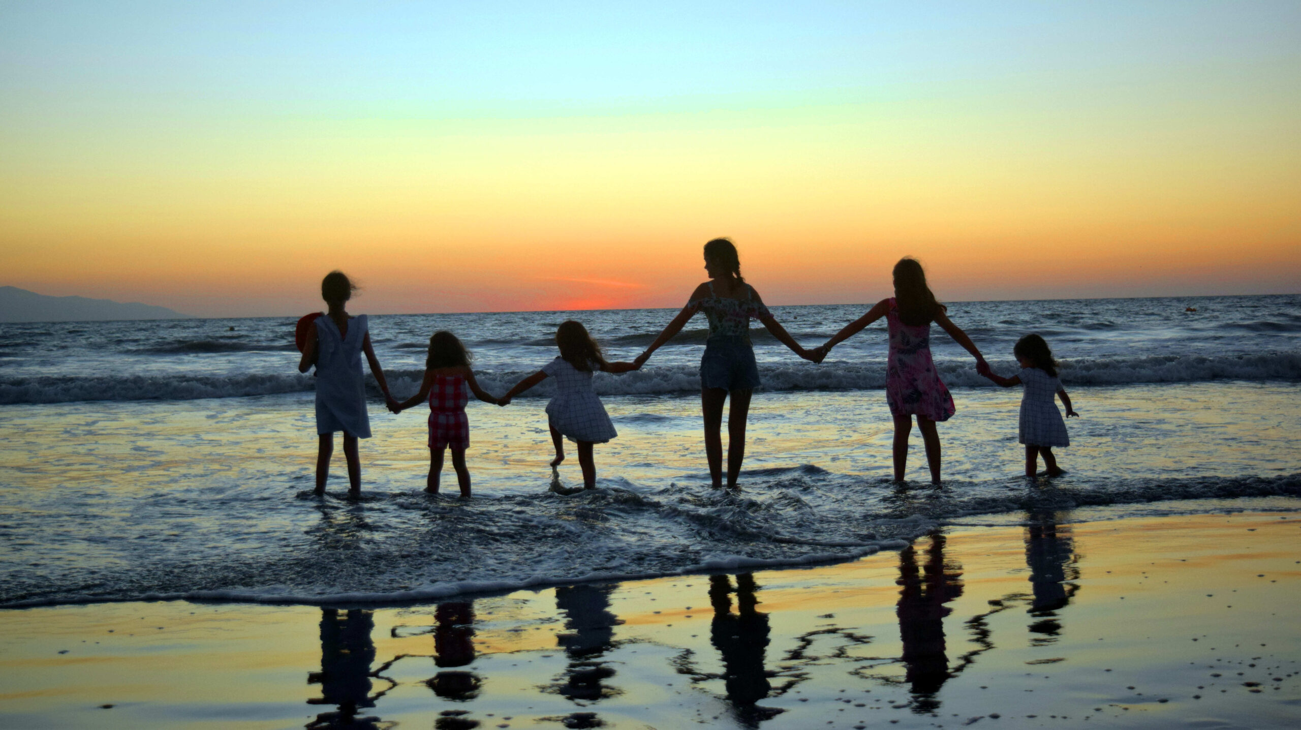 a big family holding hands at the seaside