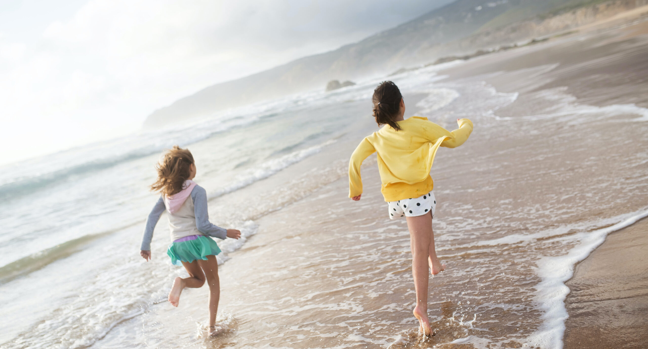 two children running on a beach