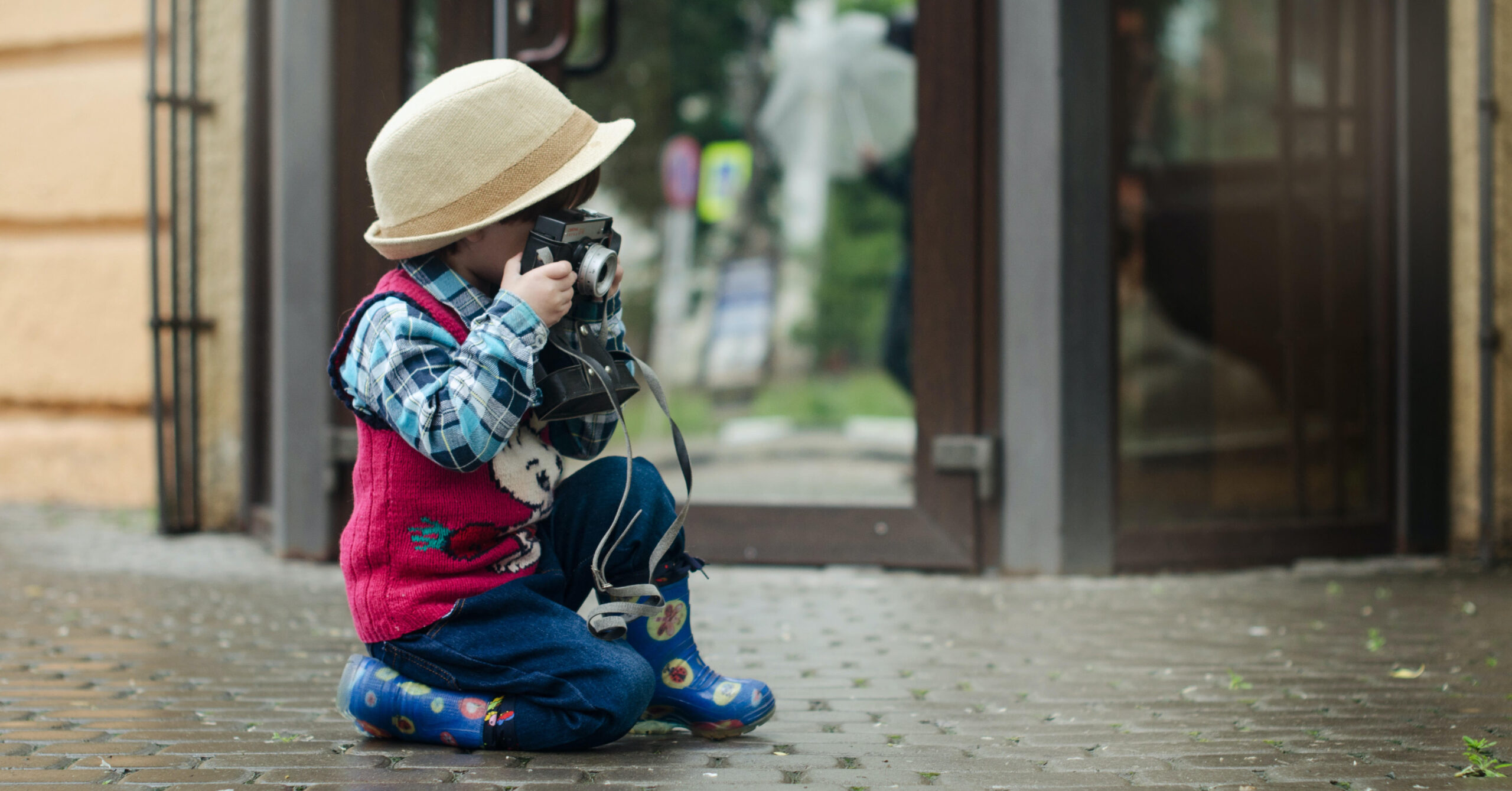 child in hat with camera