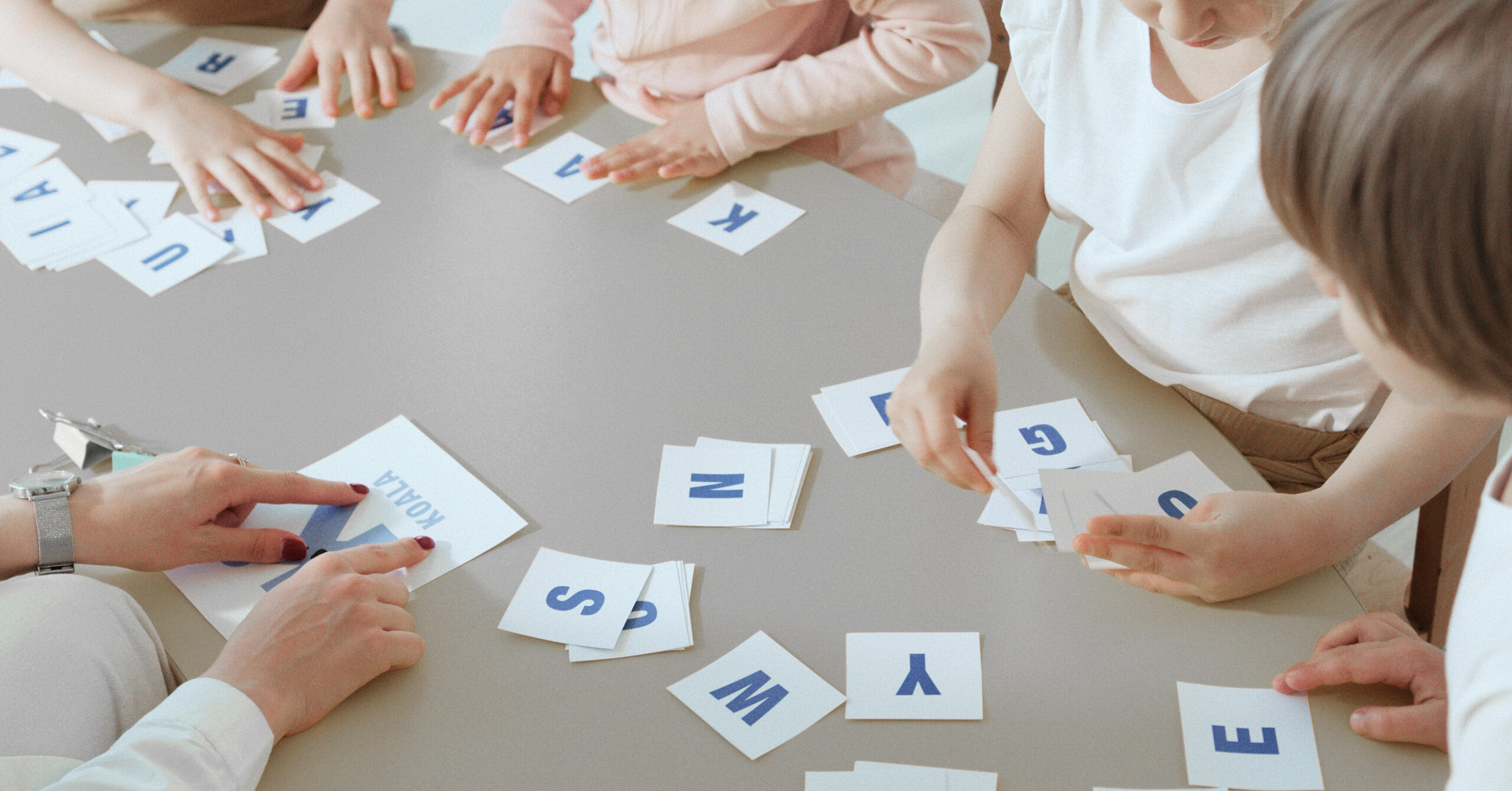 children being taught reading using flashcards