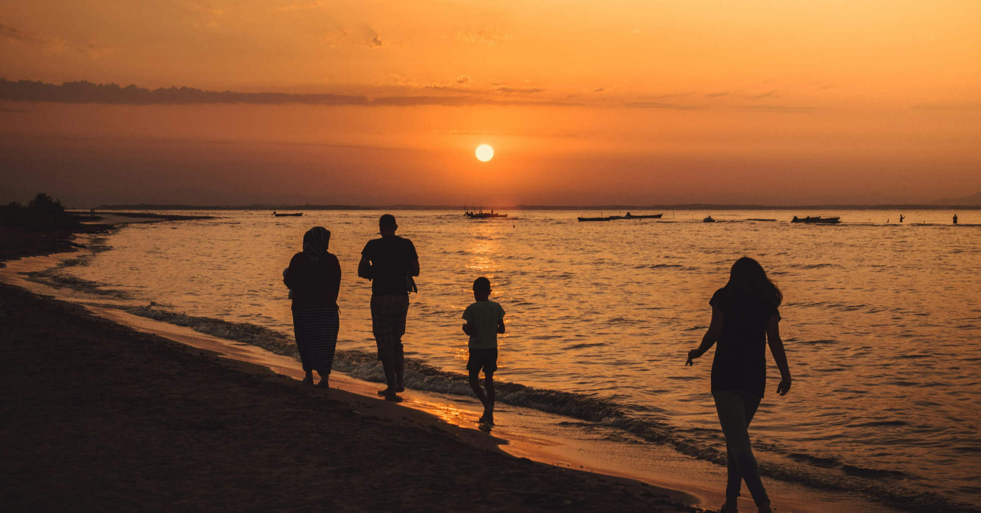 family on beach at sunset