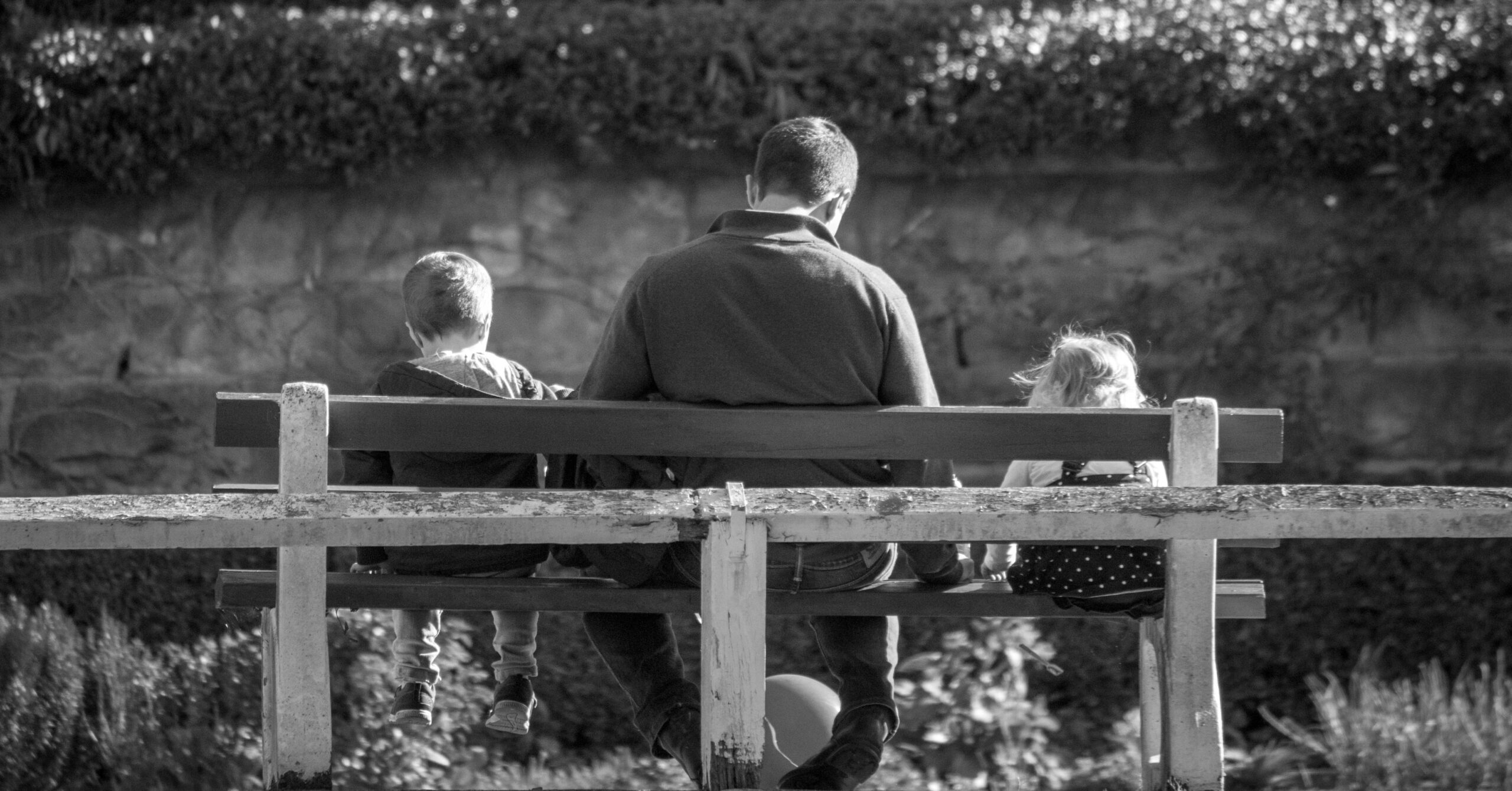 father and children sitting on a bench