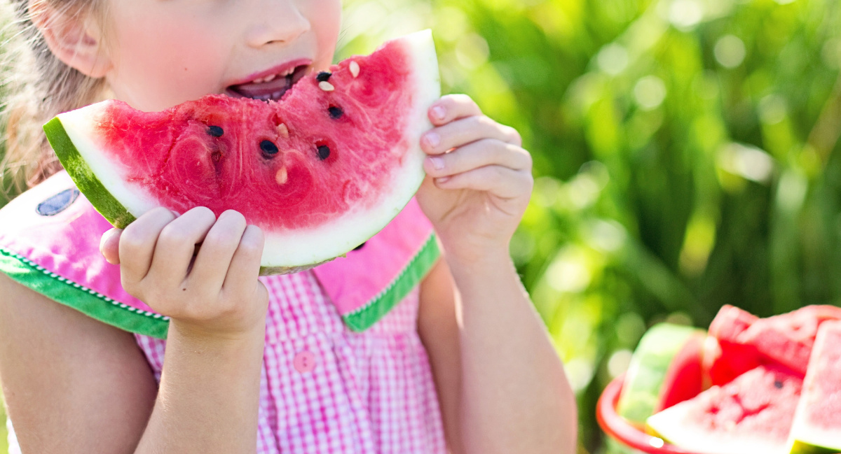a child eating a slice of watermelon
