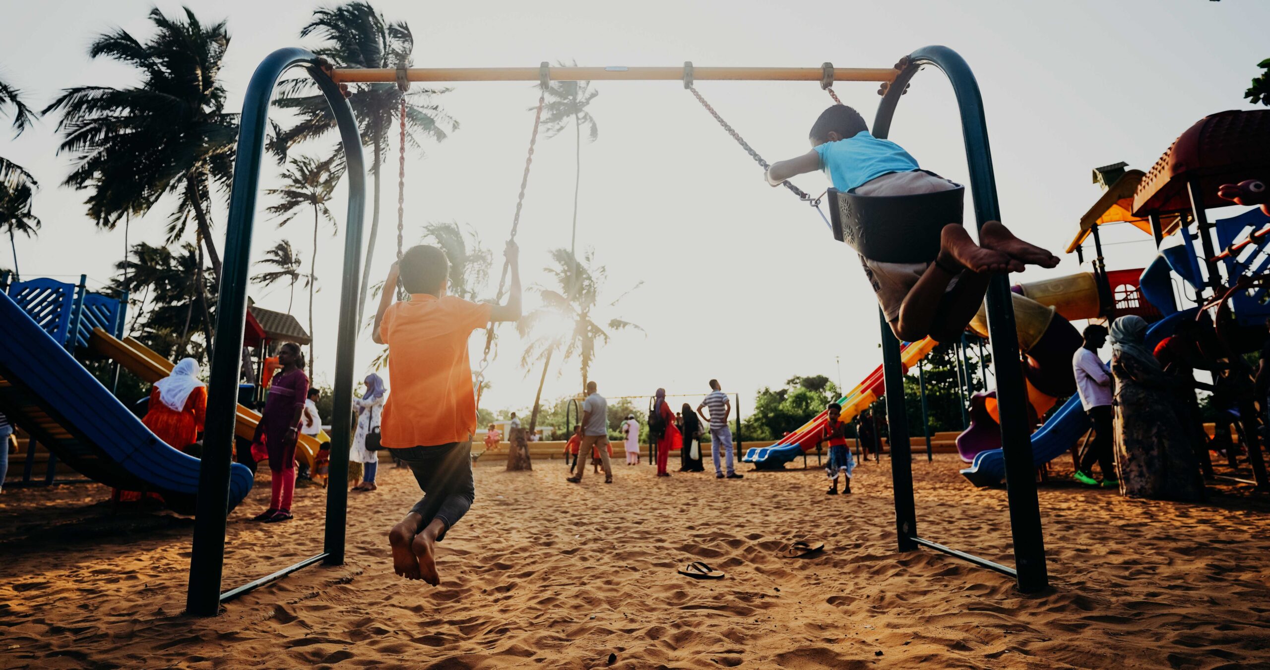 children on the swings in a play area